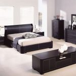 Mustat huonekalut ja makuuhuoneen seinien ja lattian valoisa sisustus