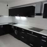 Valkoinen pöytä ja musta pesuallas modernissa keittiön sisustuksessa