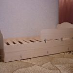 dřevěná postel se stranou
