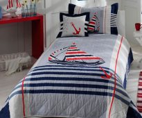 Couvre-lit de bébé sur le lit pour les garçons dans le style marin