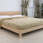 postel z masivního dřeva v ložnici