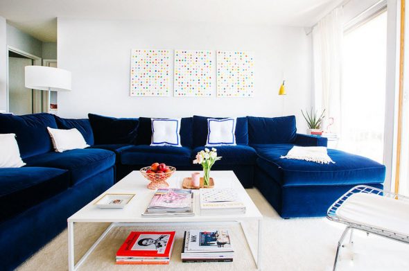 Suuri sininen sohva valoisan olohuoneen sisätiloissa