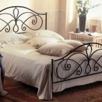 Kovaná postel dodává romantiku a barvy ložnice ve stylu Provence