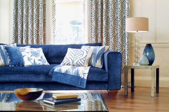 gabungan sofa biru gelap dengan lantai parket oak dan dinding berwarna pasir
