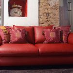 Dekorativa kuddar för en röd soffa