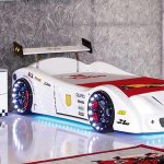 Sänky valkoisen kilpa-auton muodossa teini-huoneen huoneessa