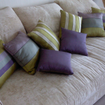 Piccoli cuscini a strisce per un divano beige