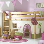 Dětská podkrovní postel, která se nachází v rohu malého dětského pokoje