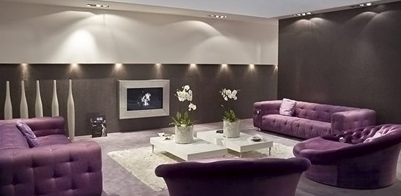 Tumma violetti sohva tilavassa huoneessa