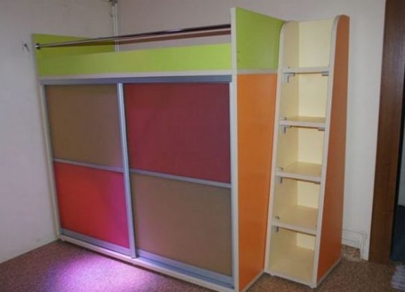 Světlá postel s mnohobarevnou šatní skříní