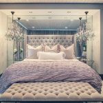 Suuri pehmeä sänky on valoisa ja kaunis makuuhuone