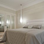 Chambre dans des couleurs gris-blanc à la mode avec un éclairage spectaculaire.