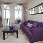 Violetti sohva ja raidallinen tuoli
