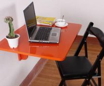 Table pliante orange pour travailler devant un ordinateur