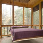 Glasbelagd veranda med en upphängd säng