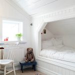 Valkoinen makuuhuone, jossa mukava sänky kapealla