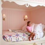 غرفة نوم الأطفال للفتاة مع سرير وصناديق مدمجة