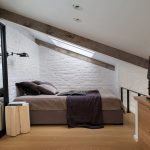 Camera da letto con pareti in mattoni in soffitta