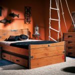 Dřevěné zásuvky pod postelí odrážejí skříňku a komodu