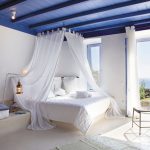 Slaapkamer met zeezicht met witte luifel