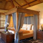 Blauwe luifel en luxe houten bed