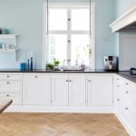 Velká bílá kuchyně se spodními skříňkami a dekorativními policemi