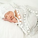שמיכה לבנה עם פומפומים לתינוק