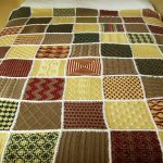 Grand plaid sur un lit de divers motifs tricotés