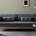 Yksinkertainen harmaa sohva, jossa on suorakulmaiset tyynyt