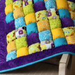 Bonbon deken met kindertekeningen met een paarse pluchen rand