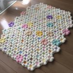 Kostkovaný koberec z jemných květin v pastelových barvách