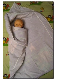 L'estremità sinistra della coperta avvolta strettamente bambino