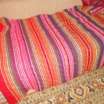 Original mångfärgad filt på sängen