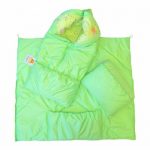 La coperta-busta di colore verde con l'aiuto di una cerniera si trasforma in una coperta e una busta