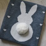 Couverture tricotée originale de fil de laine avec une jolie application en forme de lapin
