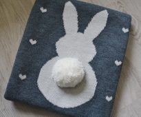 Original stickad filt av ullgarn med en söt applikation i form av en kanin
