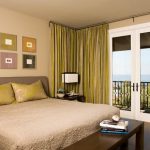 Les rideaux jaune-vert pâle sont utilisés dans la chambre à coucher avec du papier peint de sable.