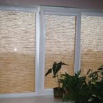 Rolde gordijnen van natuurlijk materiaal op het PVC-raam