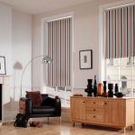 Stripade gardiner i vardagsrummet med öppen spis