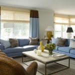 Ruskeat ja siniset verhot näyttävät näyttäviltä olohuoneessa sinisillä huonekaluilla