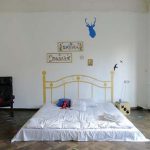 Matras op de vloer met geschilderde bylets voor decor in een minimalistisch ingerichte kamer