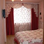 Vanliga gardiner med en blommig lambrequin för ett litet sovrum