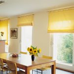 Rullade gardiner i gula på köket med fästning på taken