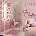 Gordijnen met een patroon en een roze achtergrond in de meisjeskamer