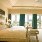 De lichtbeige kamer en de heldere smaragdgroene gordijnen vormen de perfecte combinatie voor de slaapkamer