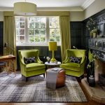 Vihreät tuolit, lampunvarjostimet ja verhot laimentavat olohuoneen mustaksi