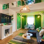Tende verdi all'interno del soggiorno-sala da pranzo dal design insolito