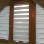 Zebra gardiner på windows i rummet på vinden i ett privat hus