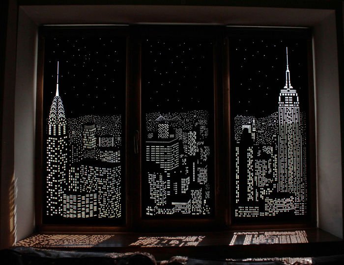 Tende arrotolate con perforazione notturna della città sulla finestra in PVC