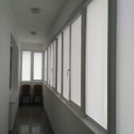 Witte gordijnen voor de ramen van een smal balkon